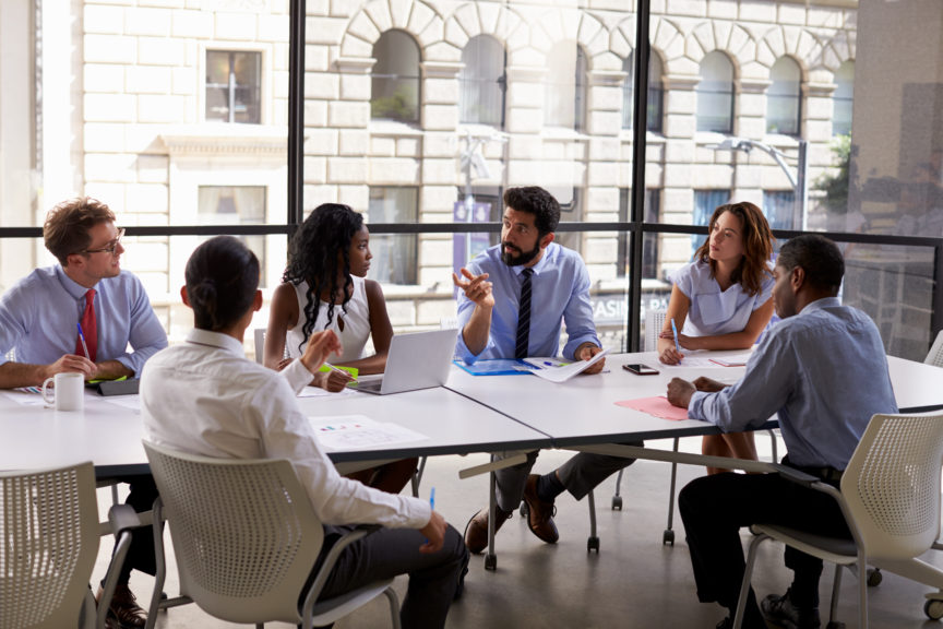 Employees discussing at conference table
